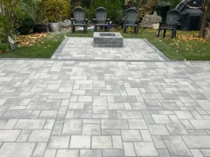 Backyard stone firepit and patio installation by Big G Landscapes