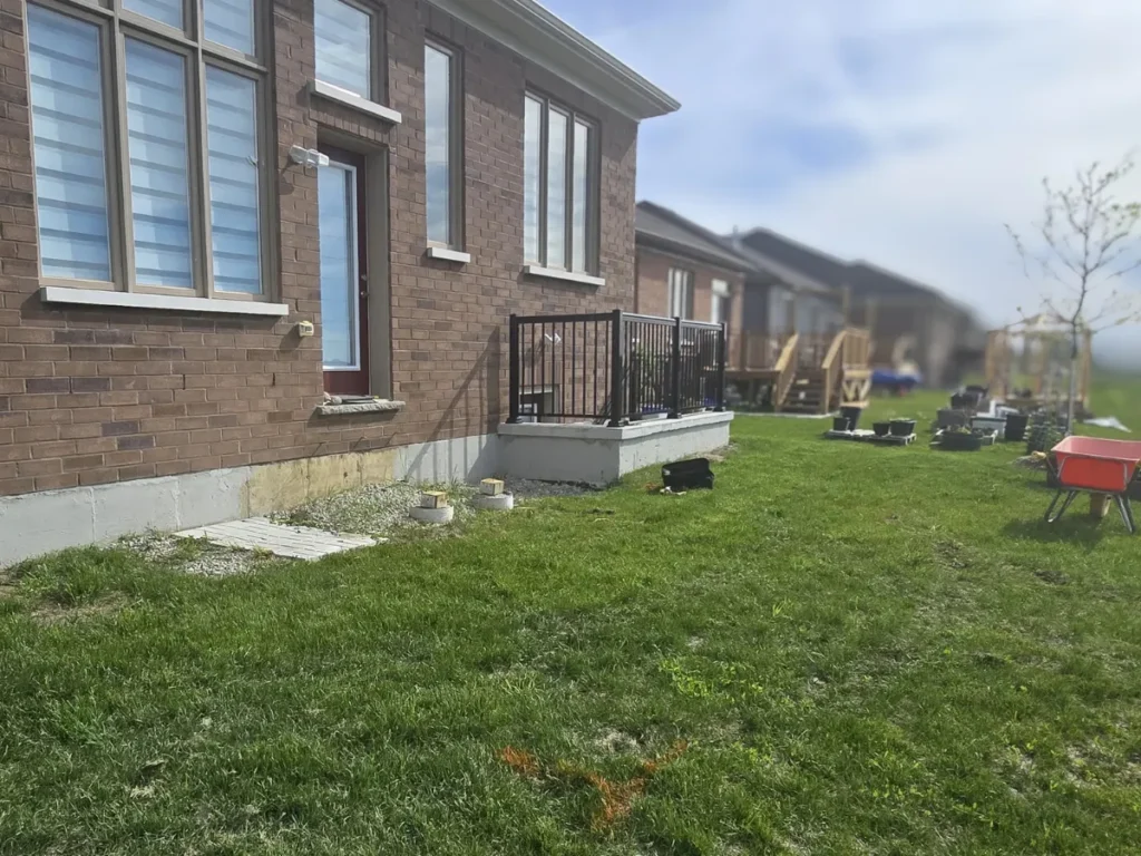 Before hardscape project showing side yard lawn area beside a brick home before new paver walkway and patio installation