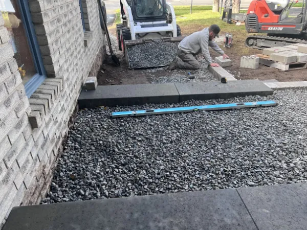 Crew levelling concrete steps during a hardscape installation beside a home in Barrie