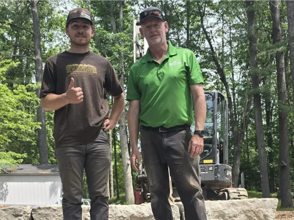 Mike Gunson and his son Colten standing together on a Big G Landscapes project site.